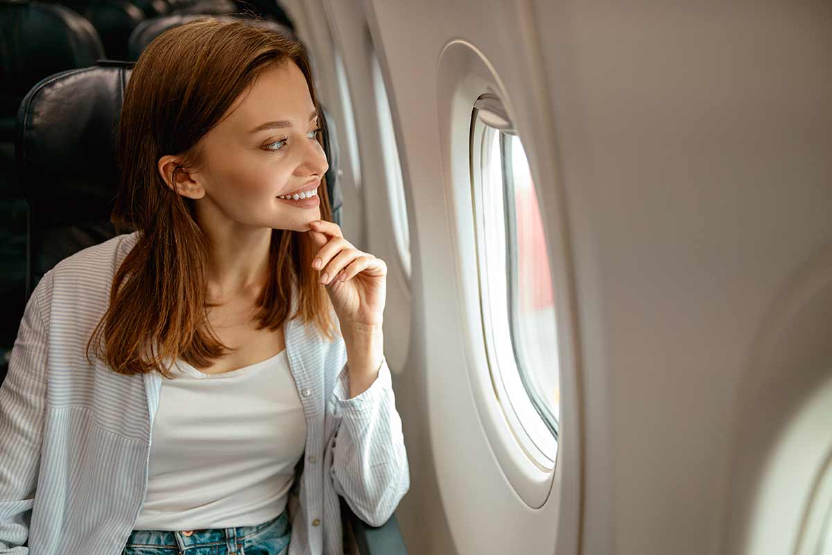 Donna in viaggio sopra un aereo.